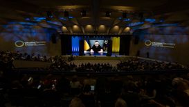 Il Presidente ucraino Volodymyr Zelenskyy, in teleconferenza, si rivolge ai partecipanti riuniti al Palazzo dei congressi (KEYSTONE/EDA/Michael Buholzer)