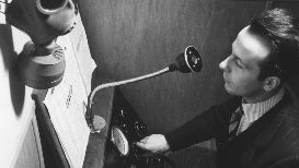 L’annunciatore Geo Molo ai microfoni della Radio svizzera con maschera antigas: inizia la guerra, 1939